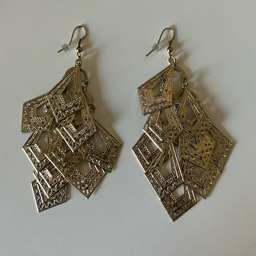 Earrings, dangling gold tone earrings.